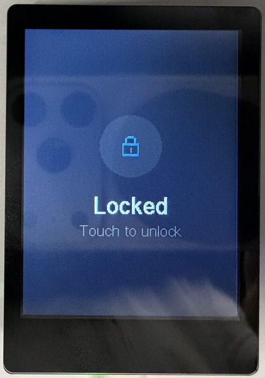 The trusted display’s Locked screen: a padlock glyph centred above “Locked” and the hint “Touch to unlock”